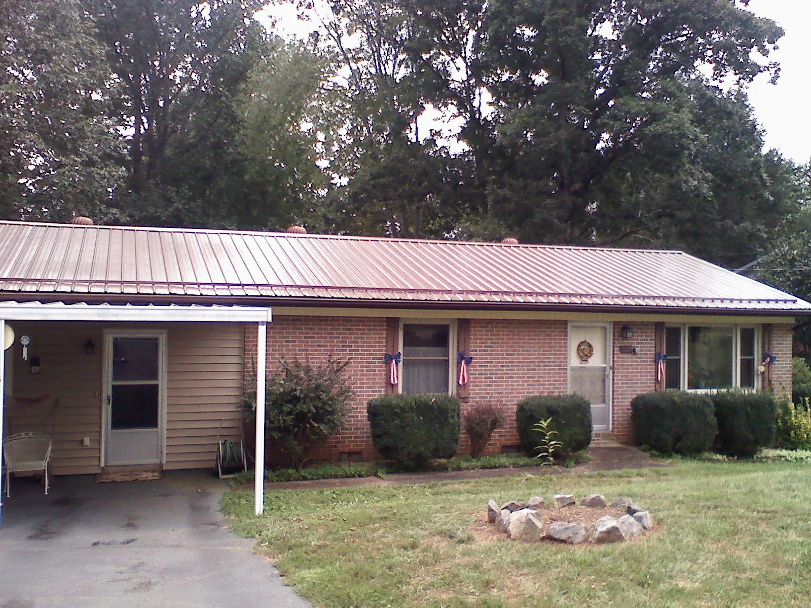 Bronze metal roof and carport on a brick ranch home — Roof Repair work by our crew in Kearneysville